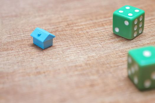 Property risks and chances concept. Miniature house and dice on wood background mortgage loans real estate taxes and debts. Symbol house investment risks insurance real estate mortgage home game dice