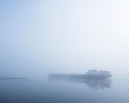 barge in the mist on river rhine near utrecht in holland