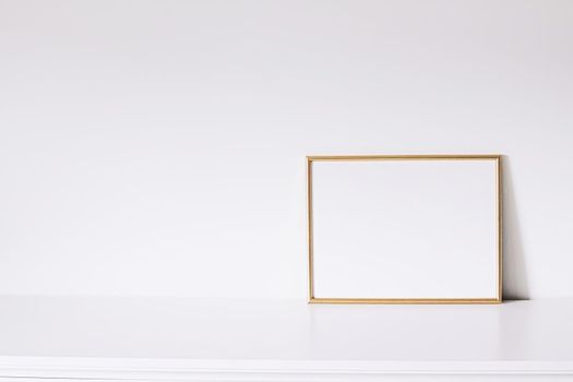 Golden horizontal frame on white furniture, luxury home decor and design for mockup creation