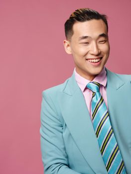 man of Asian appearance blue suit self confidence pink background