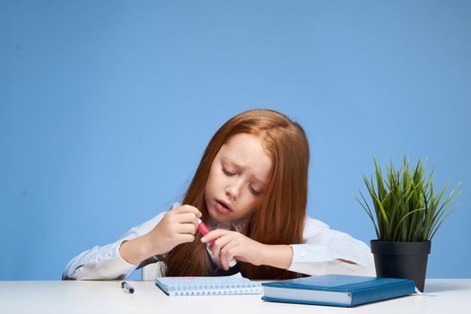 red-haired girl sitting at study table education lifestyle learning. High quality photo
