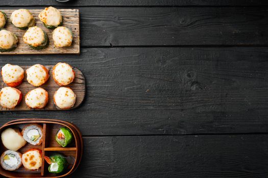 Japanese sushi rolls named Baked Ebi with wasabi and salmon fish, on black wooden table background, top view flat lay , with copyspace and space for text