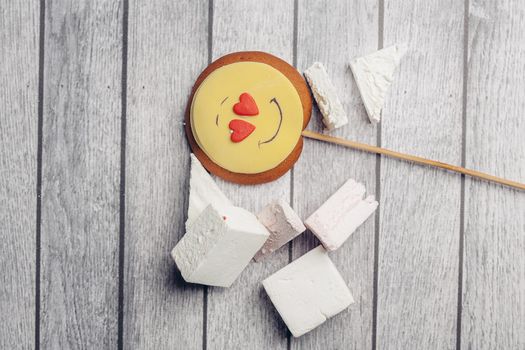 gingerbread in the form of a smiley on a stick marmalade sweets dessert enjoyment wooden background