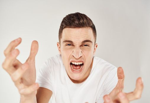 Crazy man gesturing with his hands on a light background Scream stress irritability