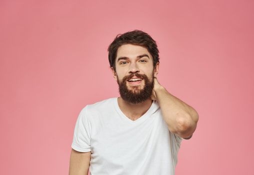 An energetic man on a pink background gestures with his hands