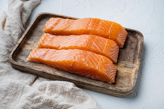 Portion of salmon fillet, on white textured background
