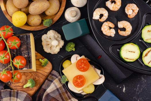 Delicious traditional Swiss melted raclette cheese on chopped boiled potatoes 