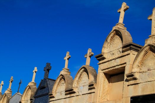 Cemetery stone crosses under blue sky
