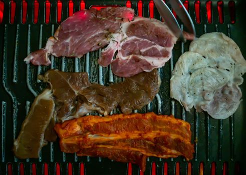 Marinated pork meat and Streaky pork grilling on stove serve. Korean style barbecue.