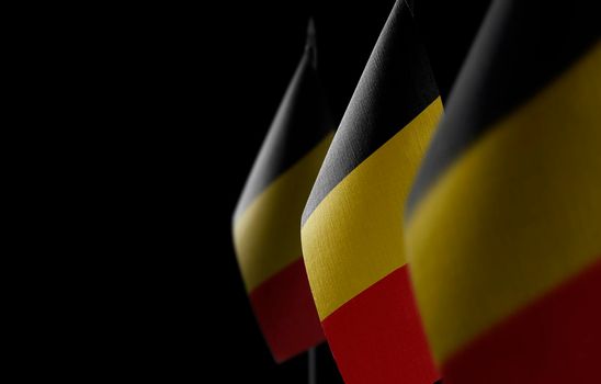 Small national flags of the Belgium on a black background