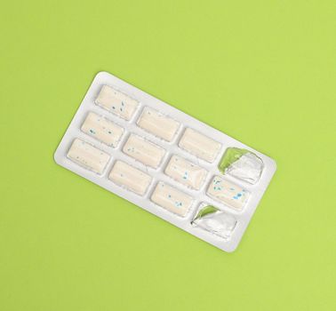 rectangular pieces of gum in a blister pack on a green background