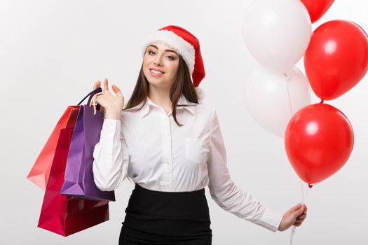 Christmas Concept - beautiful caucasian business woman happy holding shopping bags and ballons.