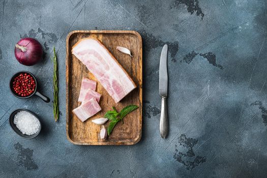 Smoked bacon, whole slab with herbs on grey textured background, top view with space for text