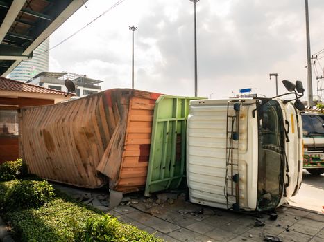 A truck carrying a container overturned on a road.