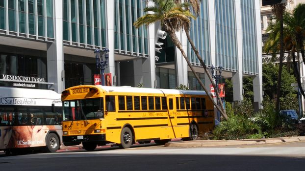 Yellow school bus on city street. Schoolbus shuttle on road. Education transport in California USA.