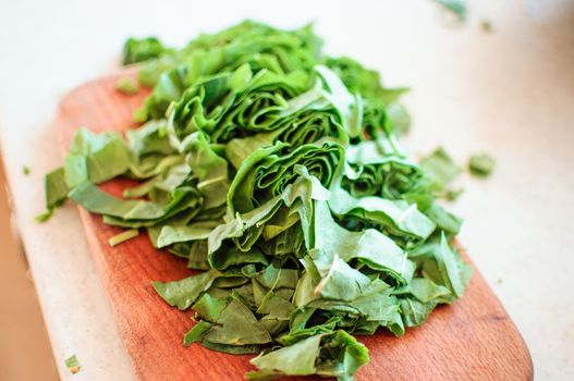 Fresh organic sorrel,plant spinach heap on wooden table for spring green vegetables soup and salad.Raw sorrel leaves top view green vegetable background.Spring green vegetables,sorrel spinach