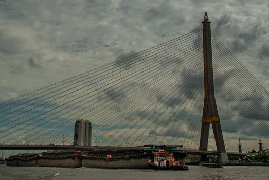 Rama VIII bridge, Rope Bridge across the Chao Phraya River, A tall V-shape pylon tower with view blue sky is background, Cloudy day