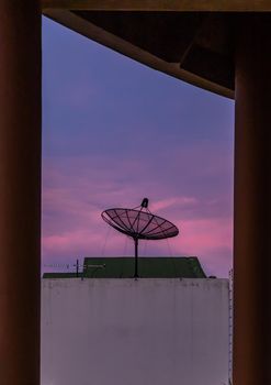 Black Satellite Dish Antenna Receiver Against on Blue Sky background.