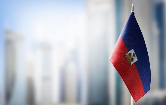 A small flag of Haiti on the background of a blurred background