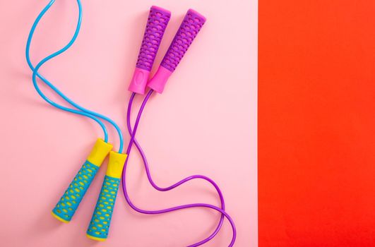 Minimalism fitness concept. Skipping rope on color background.