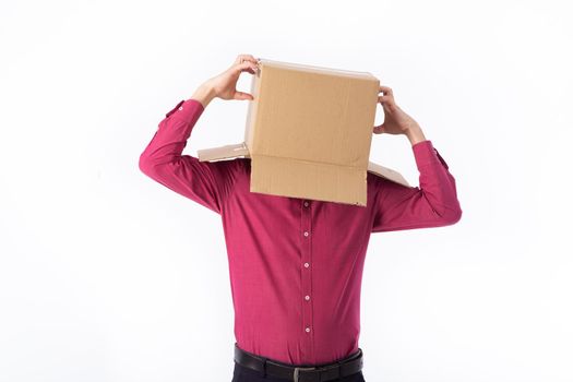 man in a red shirt with a cardboard box on his head makes a gesture with his hands