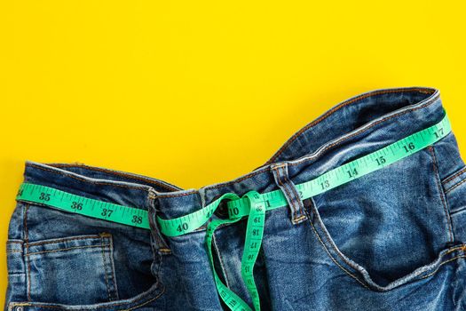 jeans with meter belt slimming on the yellow background.