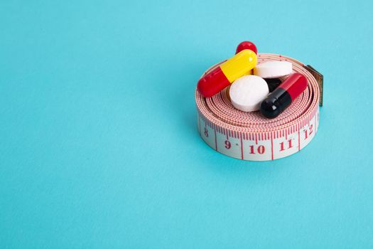 Measuring tape and pills for dieting concept.