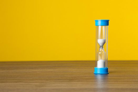 Time sand on yellow background