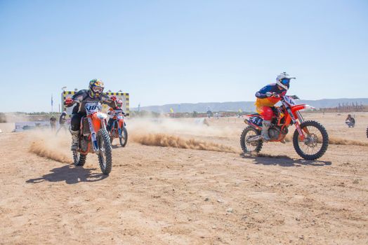 Off-road dirt bikes competing in a desert motocross rally