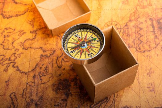 Compass beside a box on a map as concept of traveling 