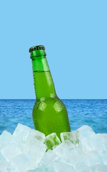 Bottle of cold lager beer on ice over sea
