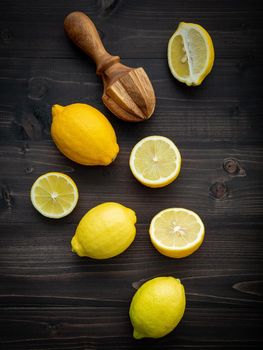 Fresh lemons and  lemons leaves on shabby wooden background.