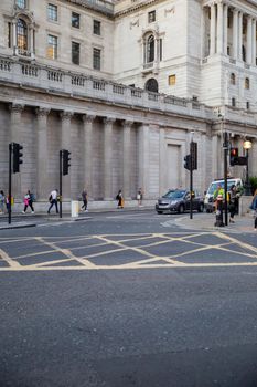 British street with pedestrians walking outside a big classical building