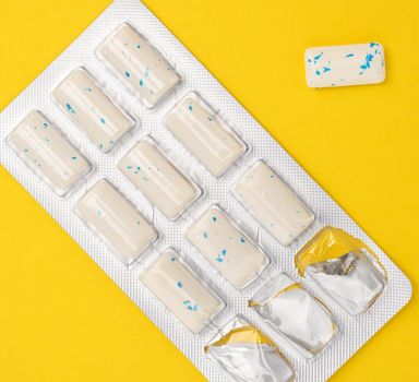 rectangular pieces of gum in a blister pack on a yellow background