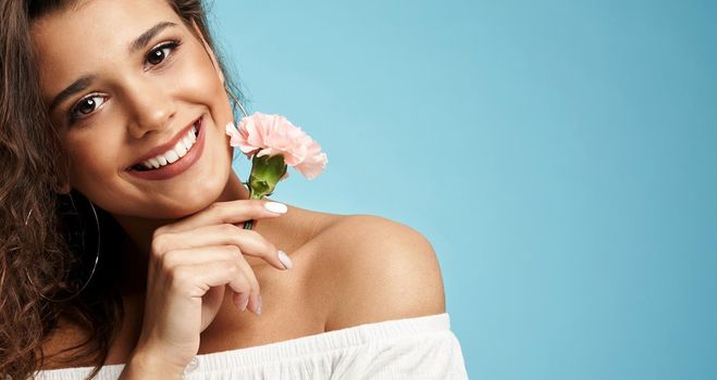 Smiling woman holding clove flower.