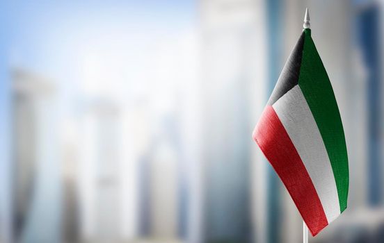 A small flag of Kuwait on the background of a blurred background