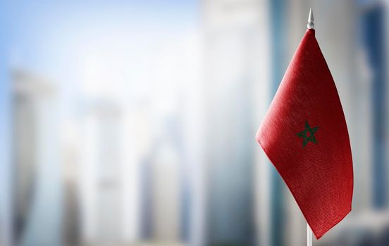 A small flag of Morocco on the background of a blurred background
