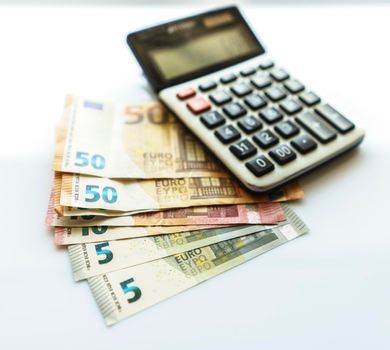 Banknotes and Calculator, Euro Banknotes on White Background