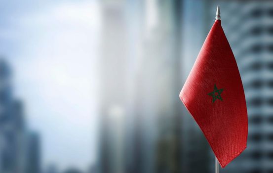 A small flag of Morocco on the background of a blurred background