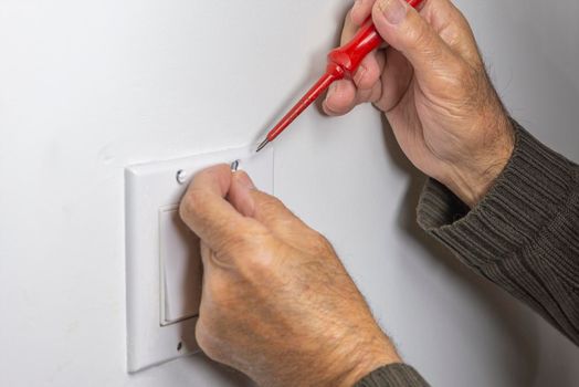 Electrician prepares screws for securing the switch cover