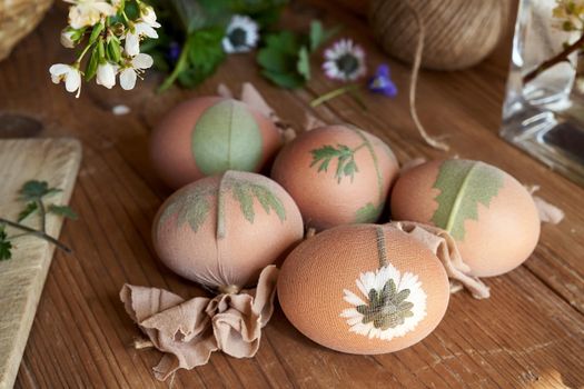 Easter eggs with leaves attached to them, ready to be dyed with onion peels