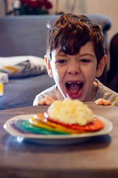 Boy Looking At A Plate Of Colorful Pancakes