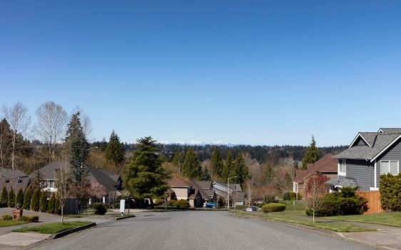 Spring day view of a residential neighborhood community in Washington State USA, with view of cascade mountains in background