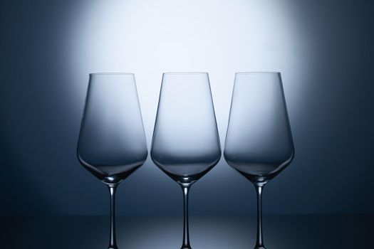 Empty wine glasses on a blue clean gradient background. 