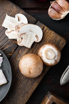 Brown champignons mushroom, on old dark wooden table background, top view flat lay