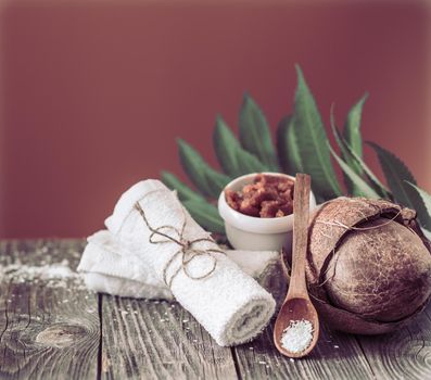 Spa and wellness setting with flowers and towels. Bright composition on brown background with tropical flowers. Dayspa nature products with coconut
