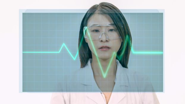 Female Asian doctor looks at virtual medical EKG screen