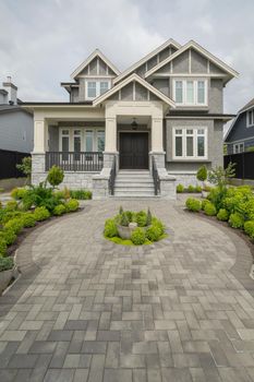 Main entrance of residential house with rounded paved pathway over front yard