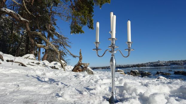 A silver candlestick by the sea on a sunny winter day in Scandinavia