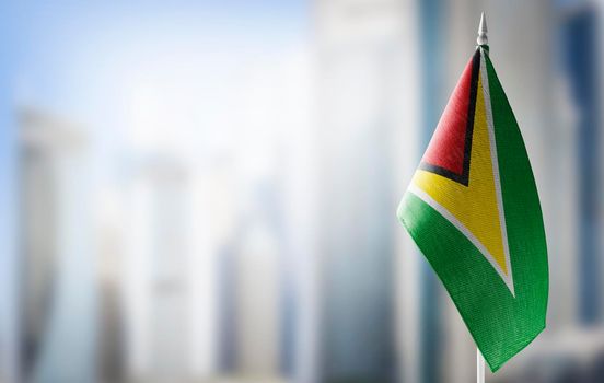 A small flag of Guyana on the background of a blurred background